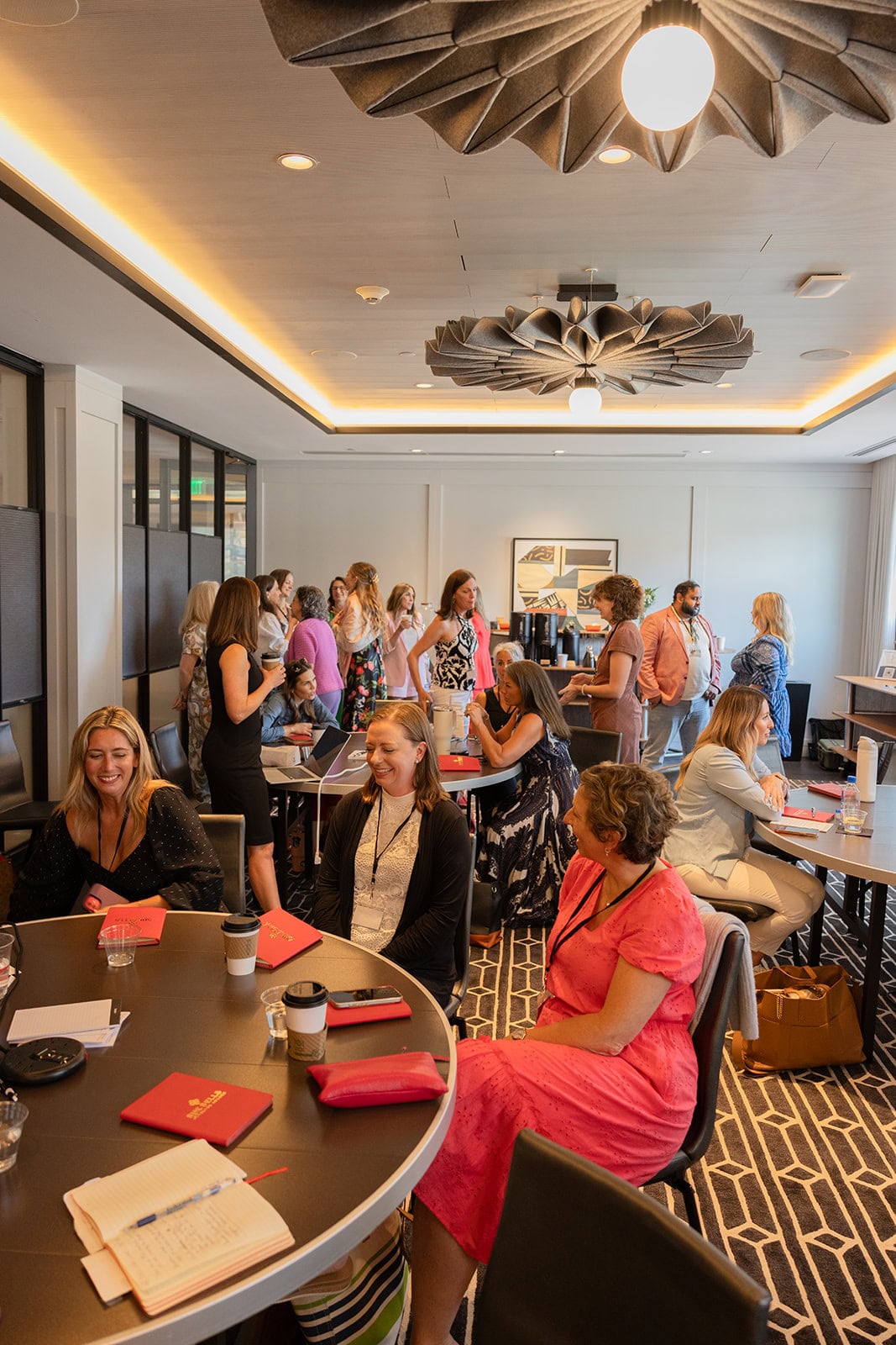 Members seated at tables talking and laughing at a Superhuman Selling live event